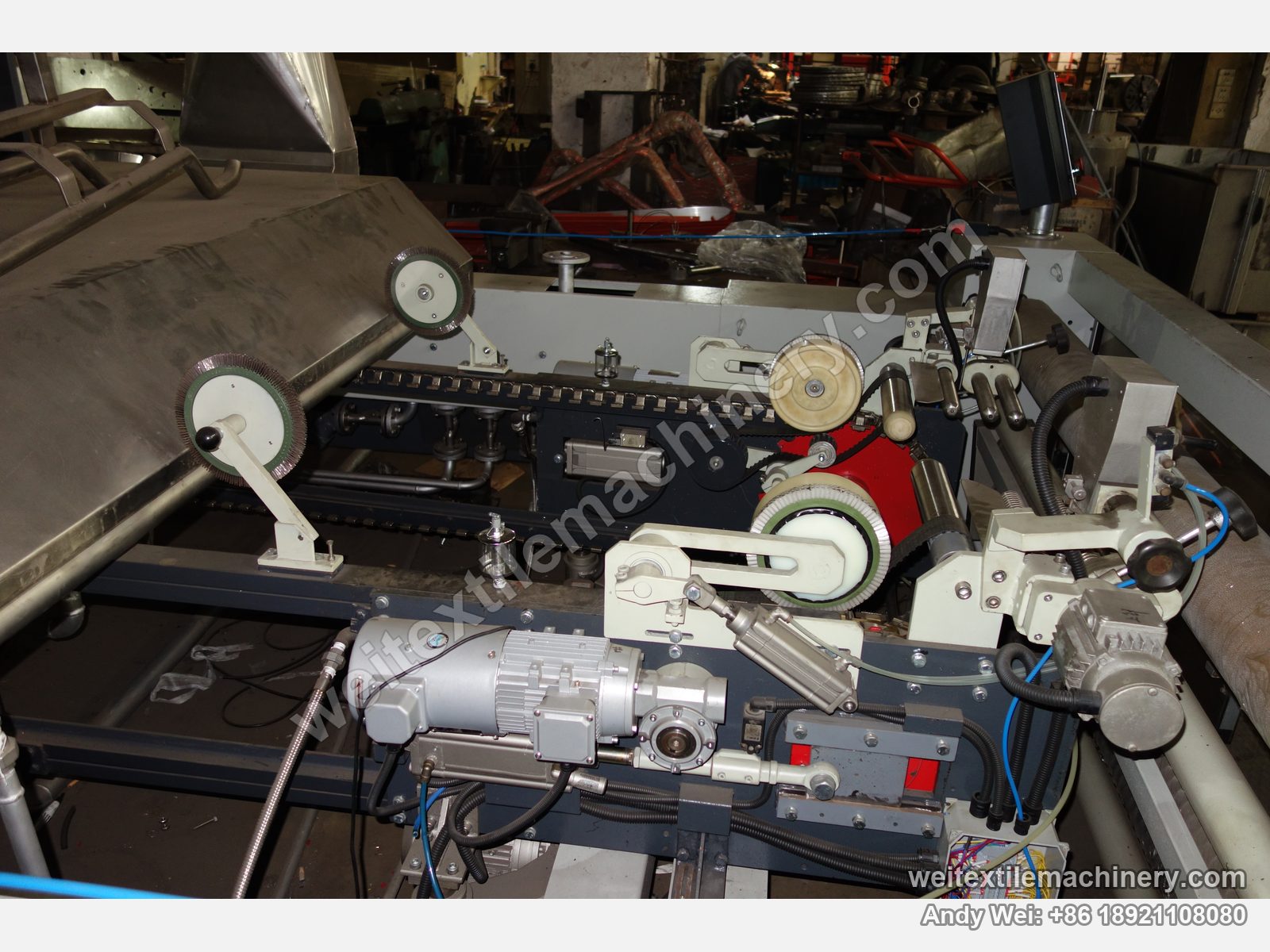 Used CoMaR SIRIO pin-chain steaming-shrinking machine, close-up of the pin chain, pinning brush wheels, pneumatic cylinder and geared motor