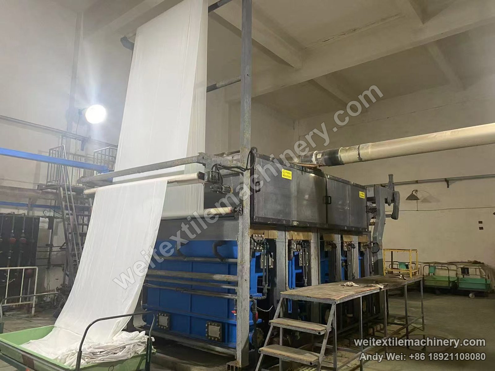 Used Kroy Fabric Machine wool fabric chlorination line, treatment tank section with blue tanks, per-tank dosing pipes and fabric delivery