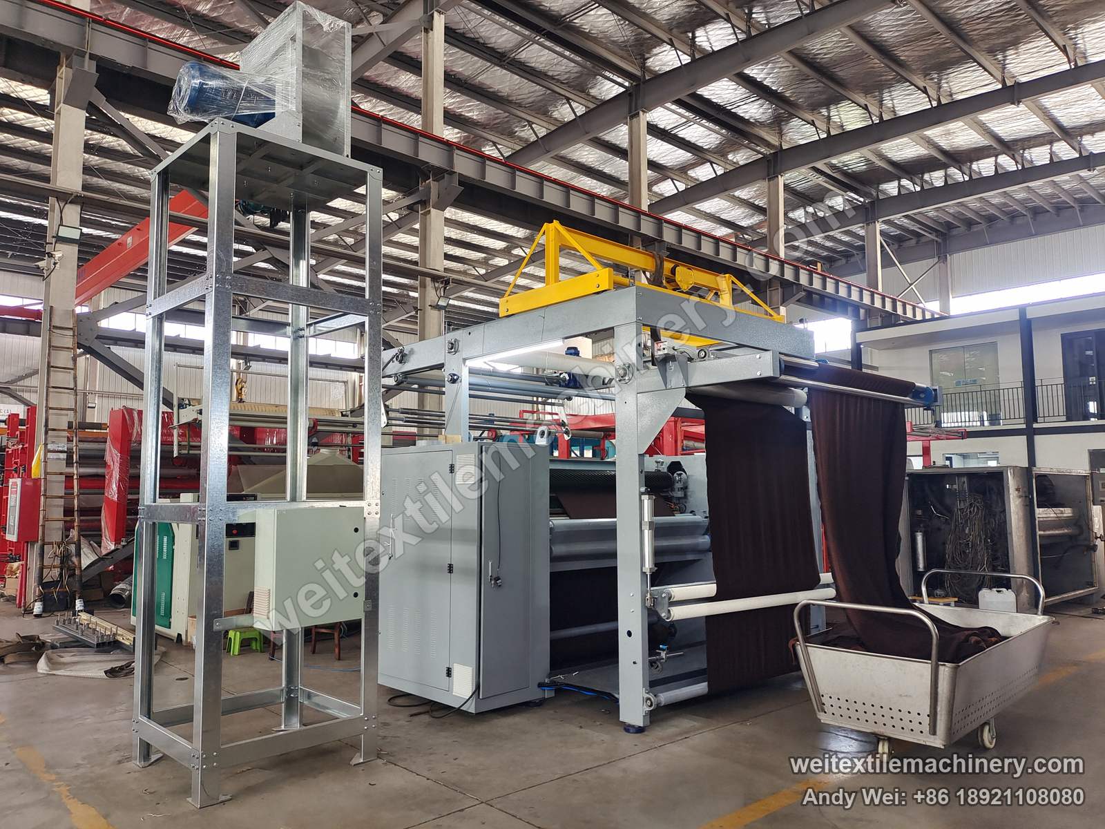 Used M-Tec shearing machine after QL rebuild, full view with grey body, yellow top frame, fabric on the overhead frame and cabinet