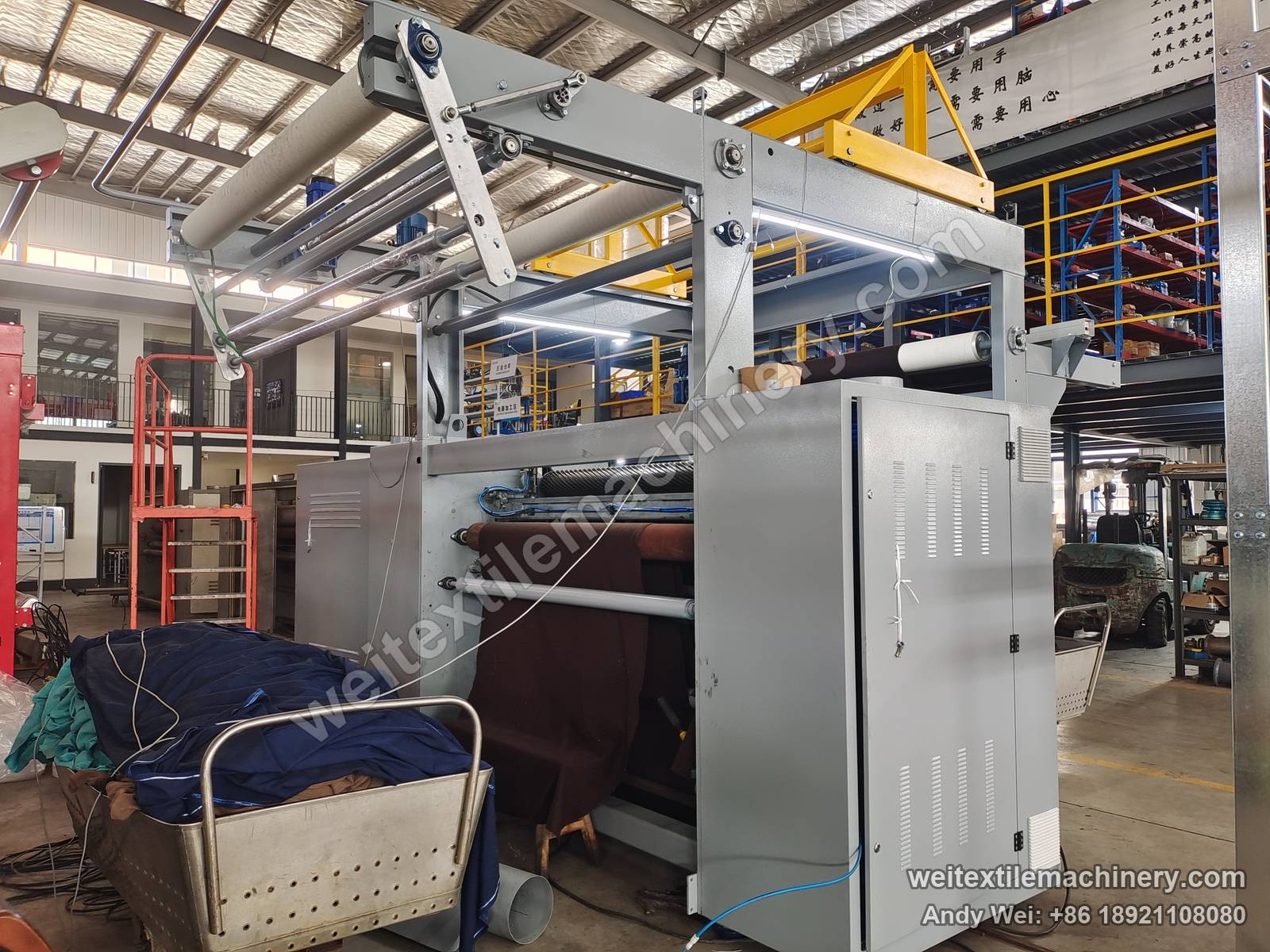 Used M-Tec shearing machine, another full view with top drive arm and guide rolls, yellow lifting beam and grey cabinet