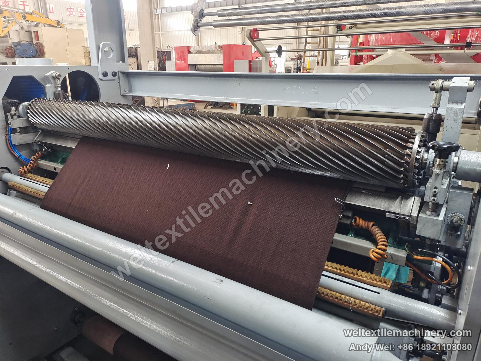 Used M-Tec shearing machine, shearing cylinder close-up with spiral blades, brushes and fabric