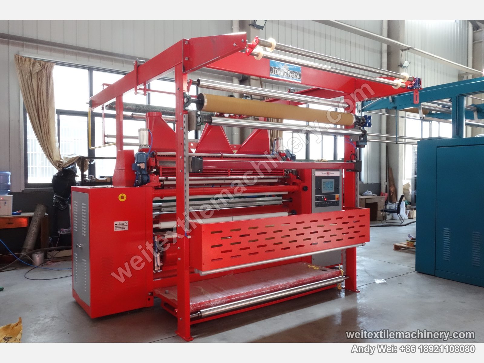 Used Mario Crosta SSC/a shearing machine, three-quarter full view with red frame, overhead fabric frame, kraft paper roll and empty shearing zone