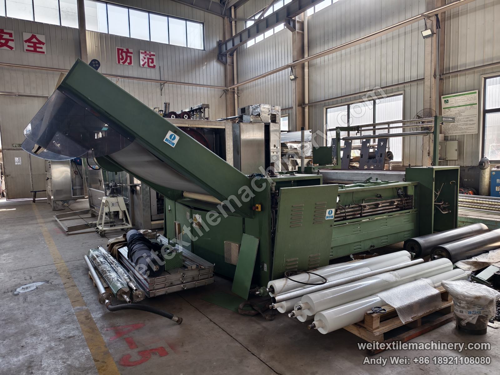 Used Sperotto Rimar belt-type steaming-shrinking machine, side view with green frame, raised inclined hood and spare rolls beside the machine