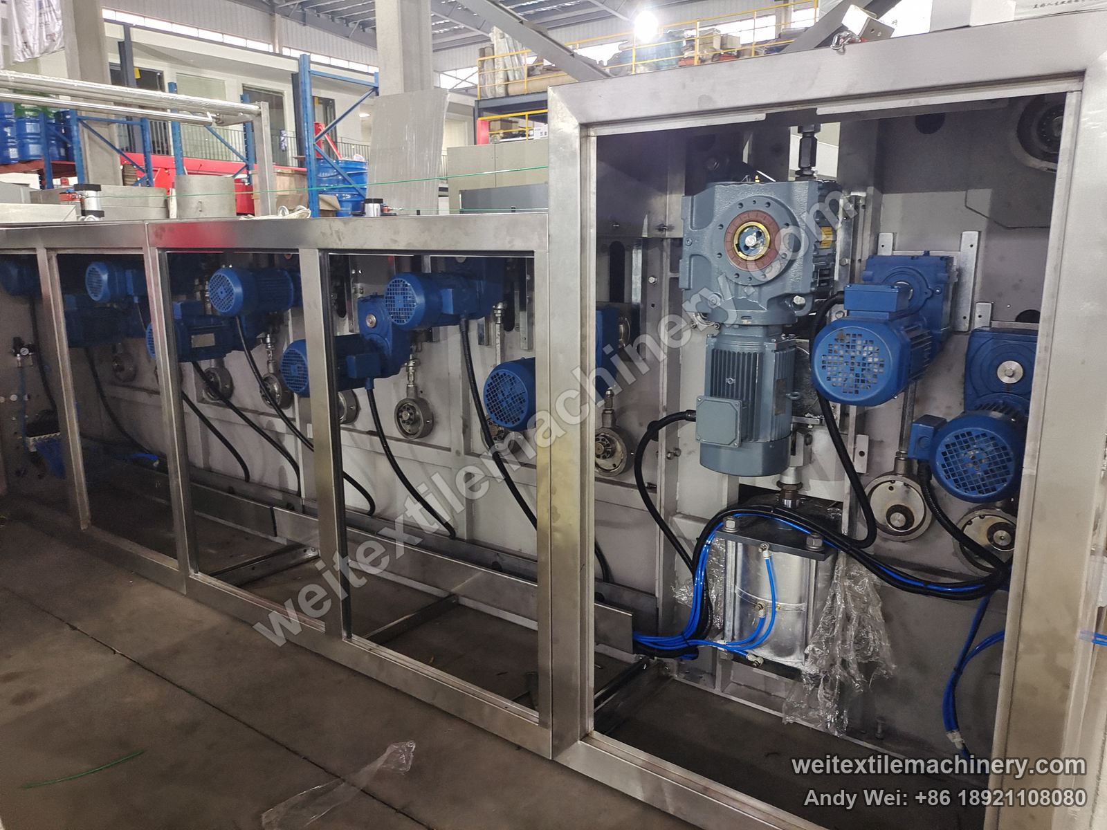Used TMT STC 4D+4R wet brushing and setting machine, drive side with opened side compartments showing a row of blue geared motors and pneumatic cylinder