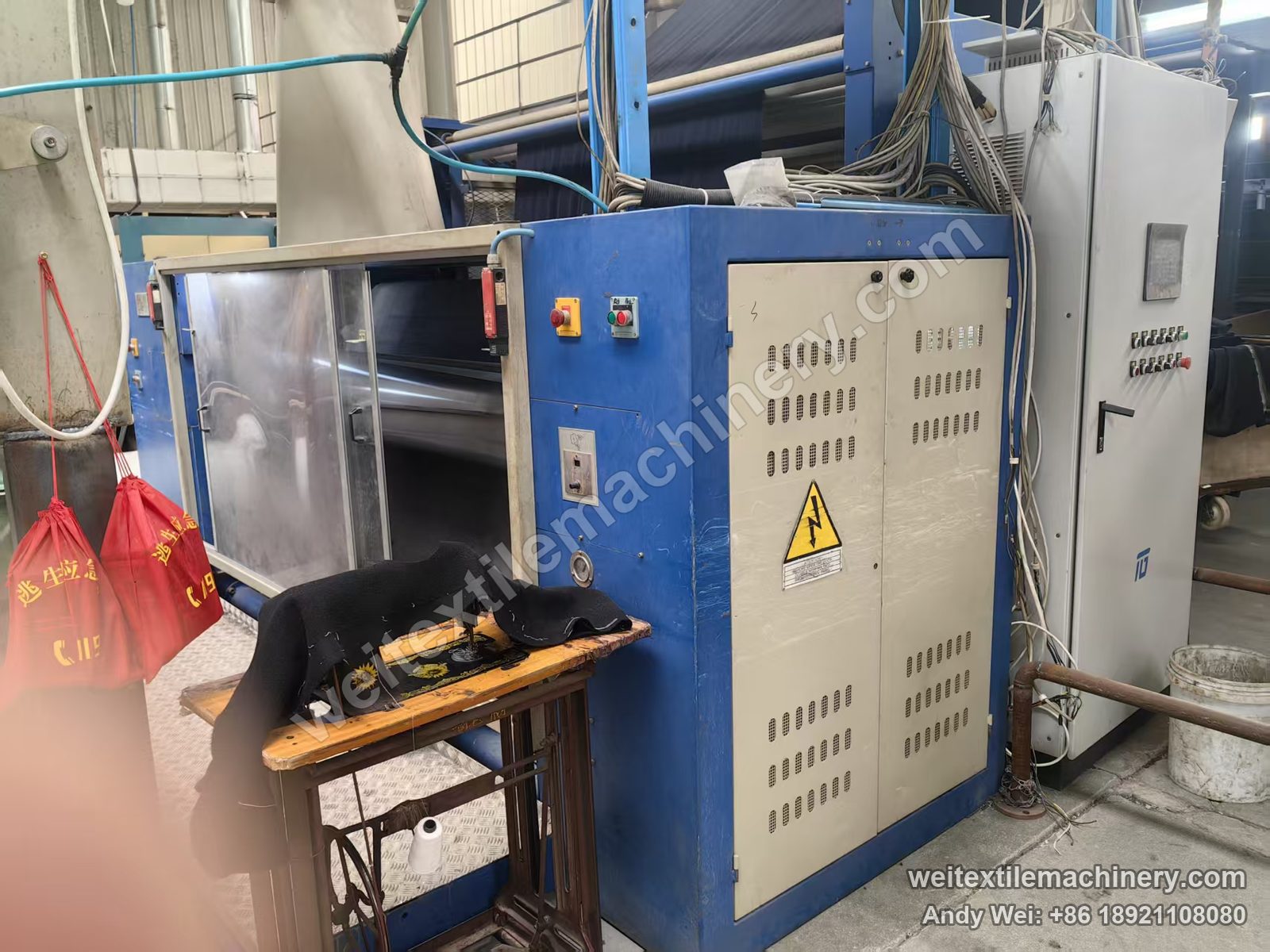 Used Unitech PRA 108 fabric polishing machine, full view with blue frame, open stainless door, emergency-stop button box and grey control cabinets at right