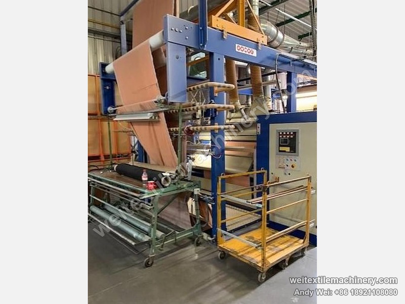 Used Unitech shearing machine (2.2 m), full view with blue frame, orange fabric on the machine, control panel and fabric trolley