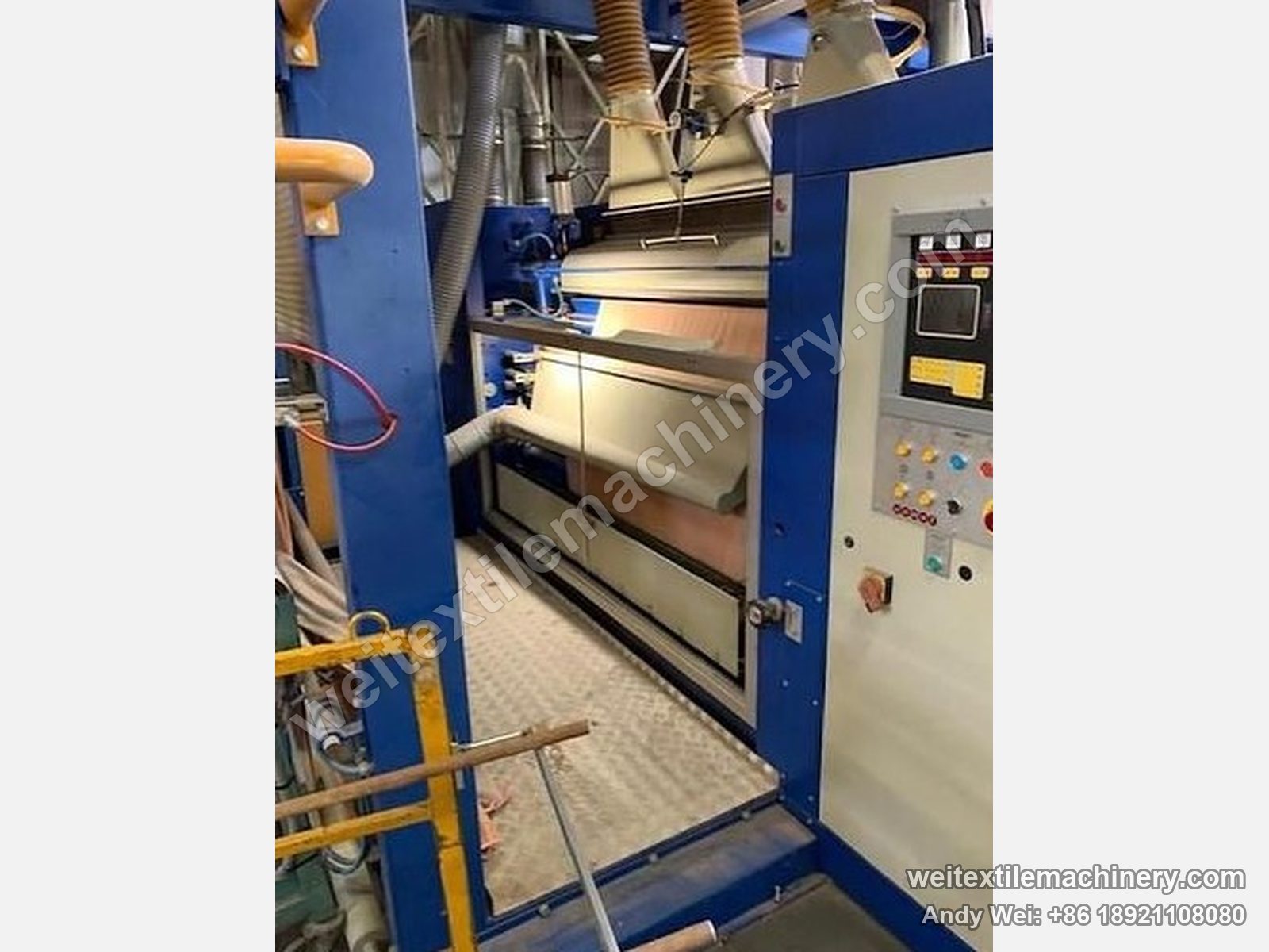 Used Unitech shearing machine (2.2 m), front view with the shearing zone open between blue columns, fabric on the machine and cabinet at right
