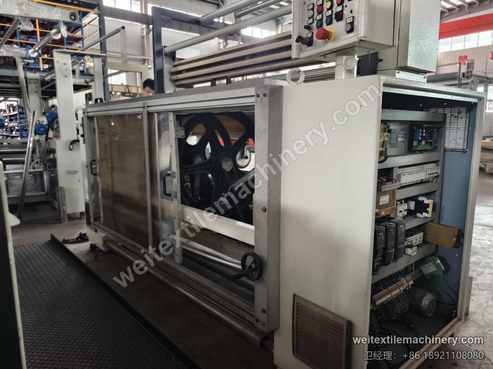 二手 Bianco Tramatex SP04 针轮式整纬机侧面，按钮操作箱、打开的电控仓与护罩内的针轮