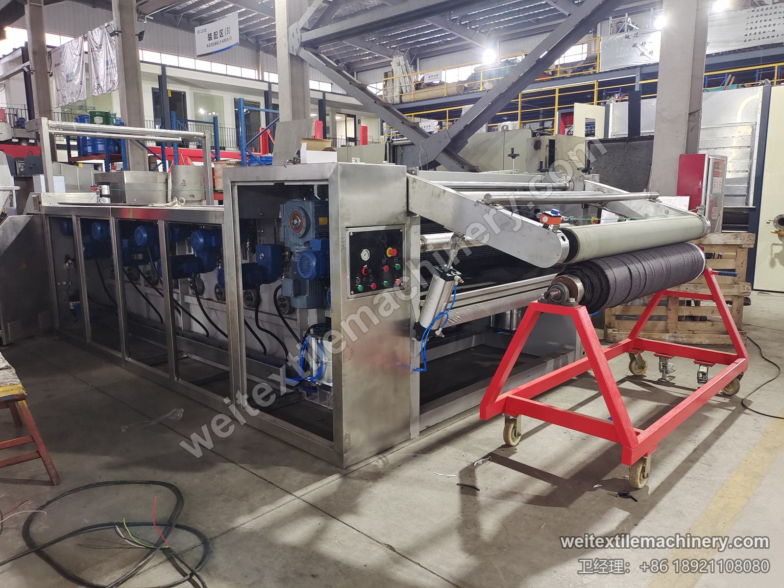 二手 TMT STC 4D+4R 湿刷毛定型机整机，不锈钢机身、一排蓝色电机、操作面板与红色布卷架车