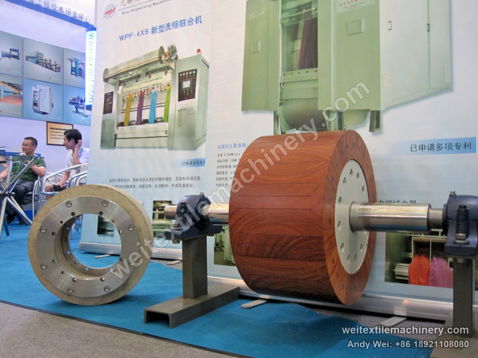 A wooden milling roller on the 2012 stand, in front of a WPF-4XS panel showing four channels running four colours of fabric