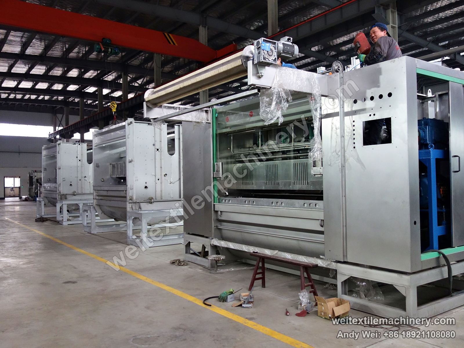 WPF-4XS in build: one machine fitted with a top roller, geared motor, blue drive unit and a viewing window, two more machine bodies behind