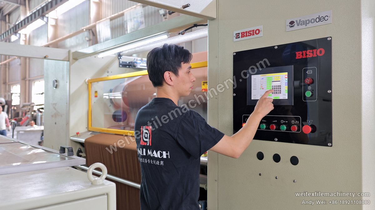 Electrical and process commissioning: a technician setting parameters on the touchscreen of a BISIO continuous decatizing machine rebuilt by QL